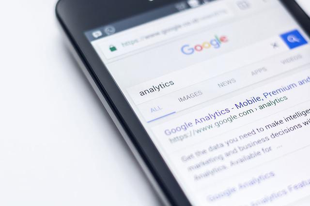 Foto de um celular com analytics escrito no campo de busca do Google